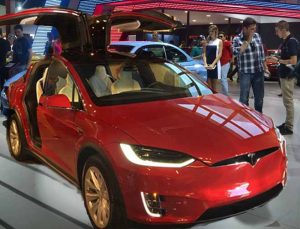 A Tesla Model X stretches its doors at an auto show