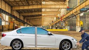 A technician tugs on the front bumper of a 3-Series BMW to convert it to a 7-Series