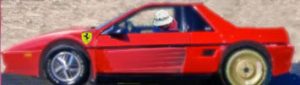 Luca di Montezemolo tries to hide his face while driving his Ferrari replica